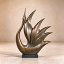 The bronze bird sculpture reveals smooth curves, recessed feather lines and mottled green-brown surface tones in a studio view for finish selection.