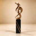 Highlighting the golden tones and abstract loops of the design, this modern bronze interior artwork is photographed against a neutral studio backdrop for luxury catalog displays.