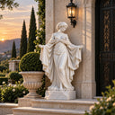 White marble classical female statue in a flowing draped robe with outstretched arms, placed at a luxury villa entrance at sunset with a wall lantern, planter, and cypress trees, ideal for high-end outdoor garden and exterior decor.