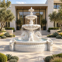 White marble three-tier fountain with horse head sculptures and shell motifs, placed in a modern luxury villa courtyard with glass walls and olive trees, ideal for high-end outdoor landscape decoration.