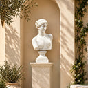 White marble Venus bust MM-023 displayed on a carved pedestal in a Mediterranean-style courtyard