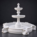 White tiered stone fountain on a dark background, showcasing detailed carved texture and shell motifs for garden decor product display and reference.